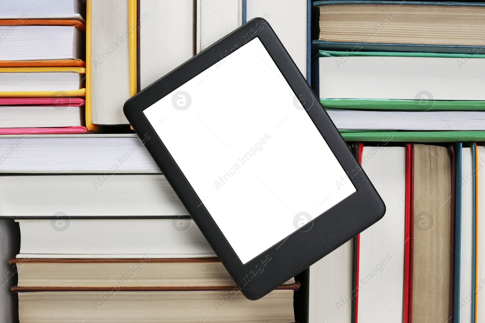 Photo of Portable e-book reader on different hardcover books, top view