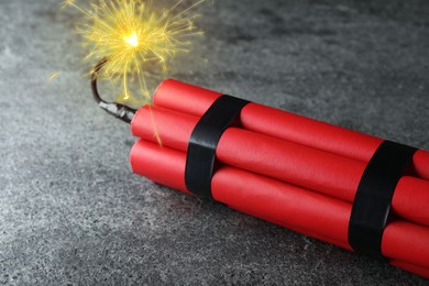 Image of Dynamite bomb with lit fuse on grey table