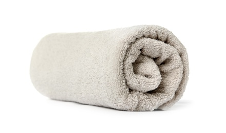 Photo of Rolled clean beige towel on white background