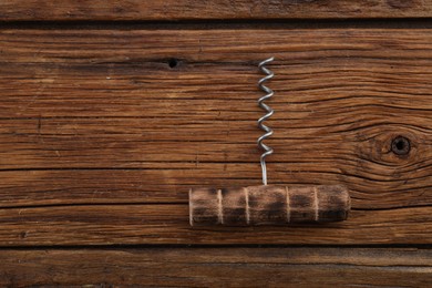 Photo of One corkscrew on wooden table, top view. Space for text