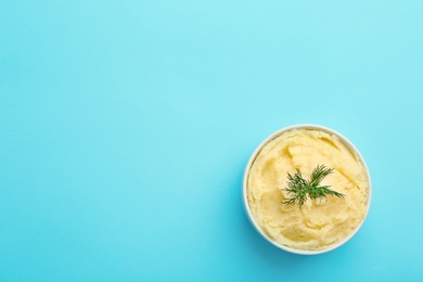 Photo of Bowl with tasty mashed potatoes and space for text on color background, top view