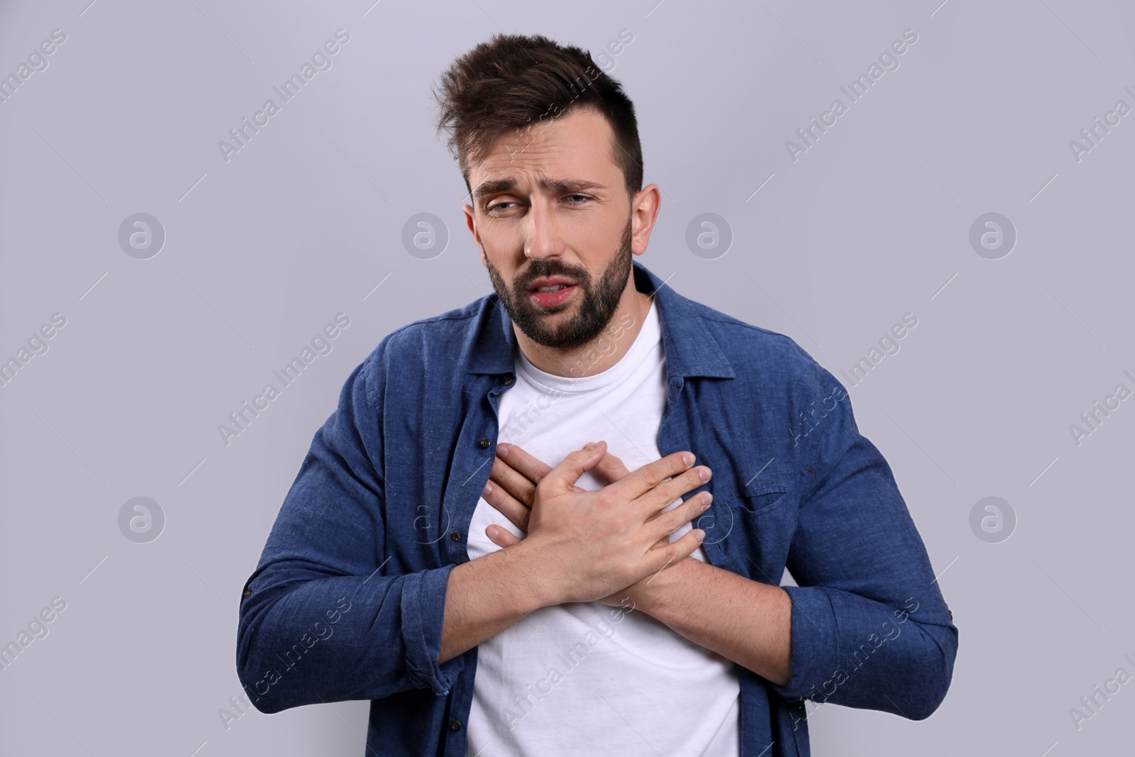 Photo of Man suffering from cold on grey background