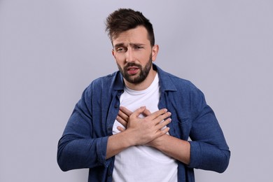 Man suffering from cold on grey background