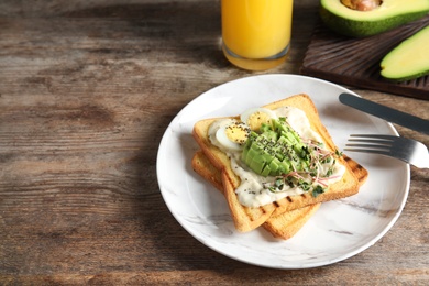 Photo of Tasty toasts with avocado, quail egg and chia seeds served on table. Space for text