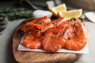 Photo of Delicious cooked shrimps on wooden board, closeup