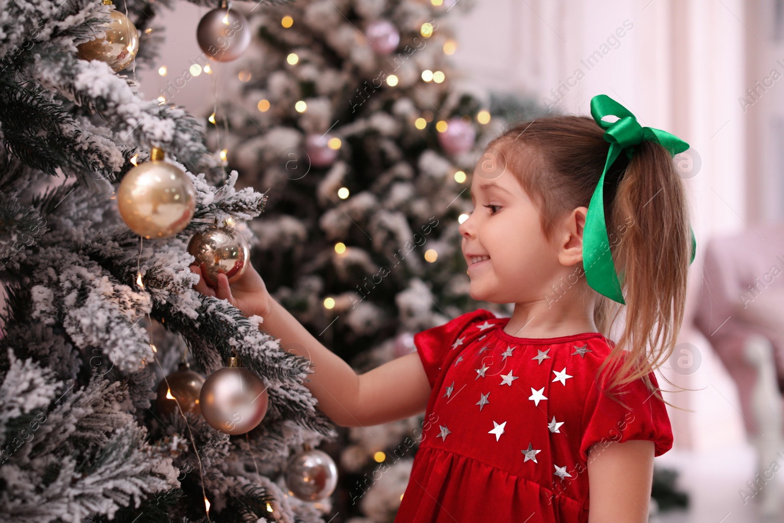 Photo of Cute little child near Christmas tree at home