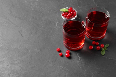 Photo of Tasty refreshing cranberry juice, mint and fresh berries on grey textured table. Space for text