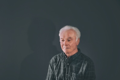 Photo of Portrait of poor elderly man on dark background