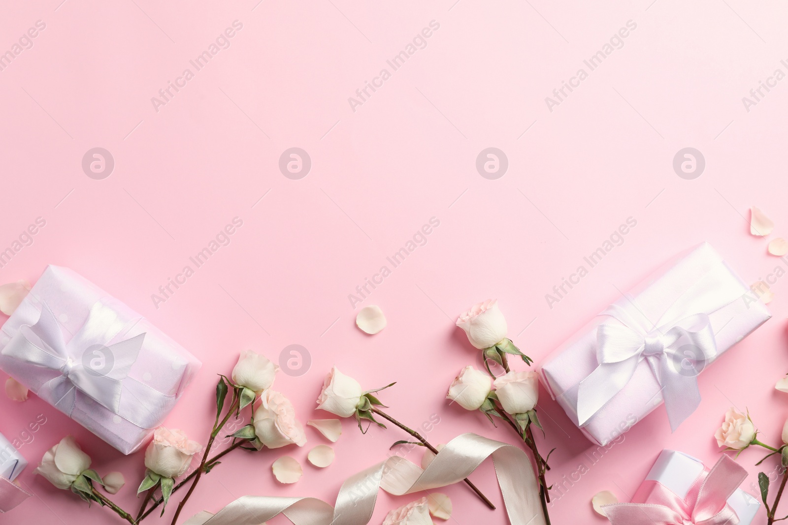 Photo of Flat lay composition with beautiful roses and gift boxes on color background. Space for text