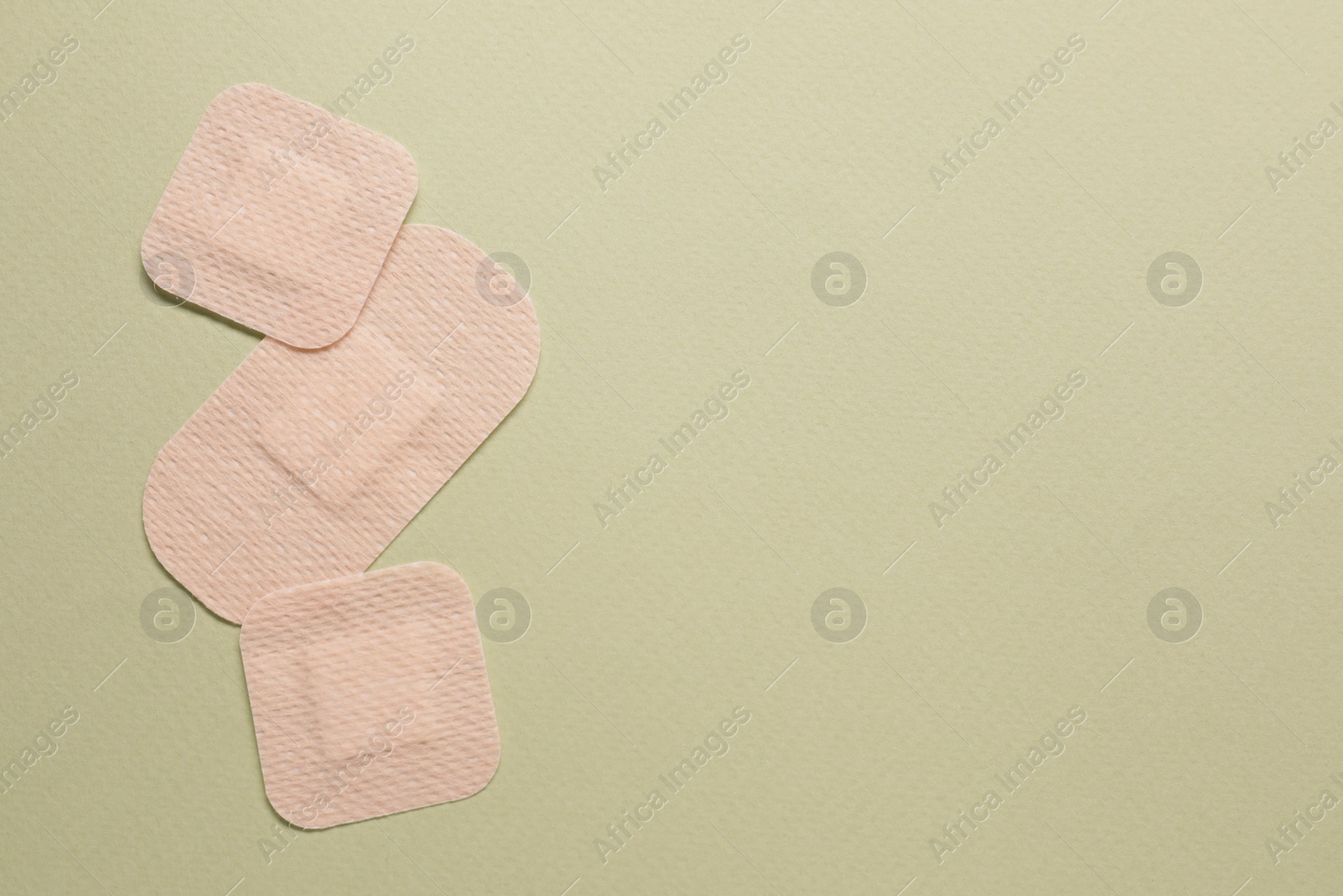 Photo of Different contraceptive patches on green background, flat lay. Space for text