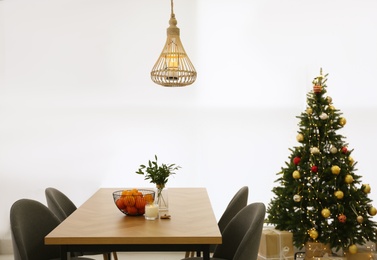 Photo of Wooden table and Christmas tree in contemporary living room. Interior design