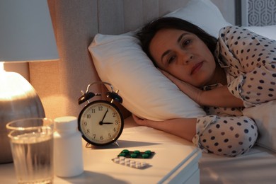 Photo of Mature woman suffering from insomnia in bed at night
