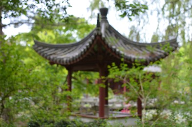 Photo of Blurred view of beautiful oriental pergola in park