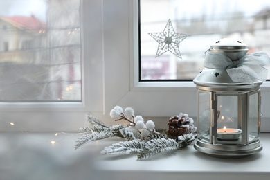 Photo of Beautiful Christmas lantern and other decorations on window sill