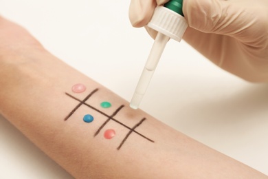 Patient undergoing skin allergy test at light table, closeup
