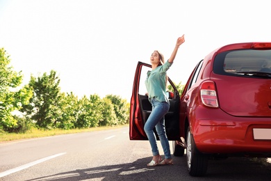 Photo of Young woman near car outdoors on sunny day