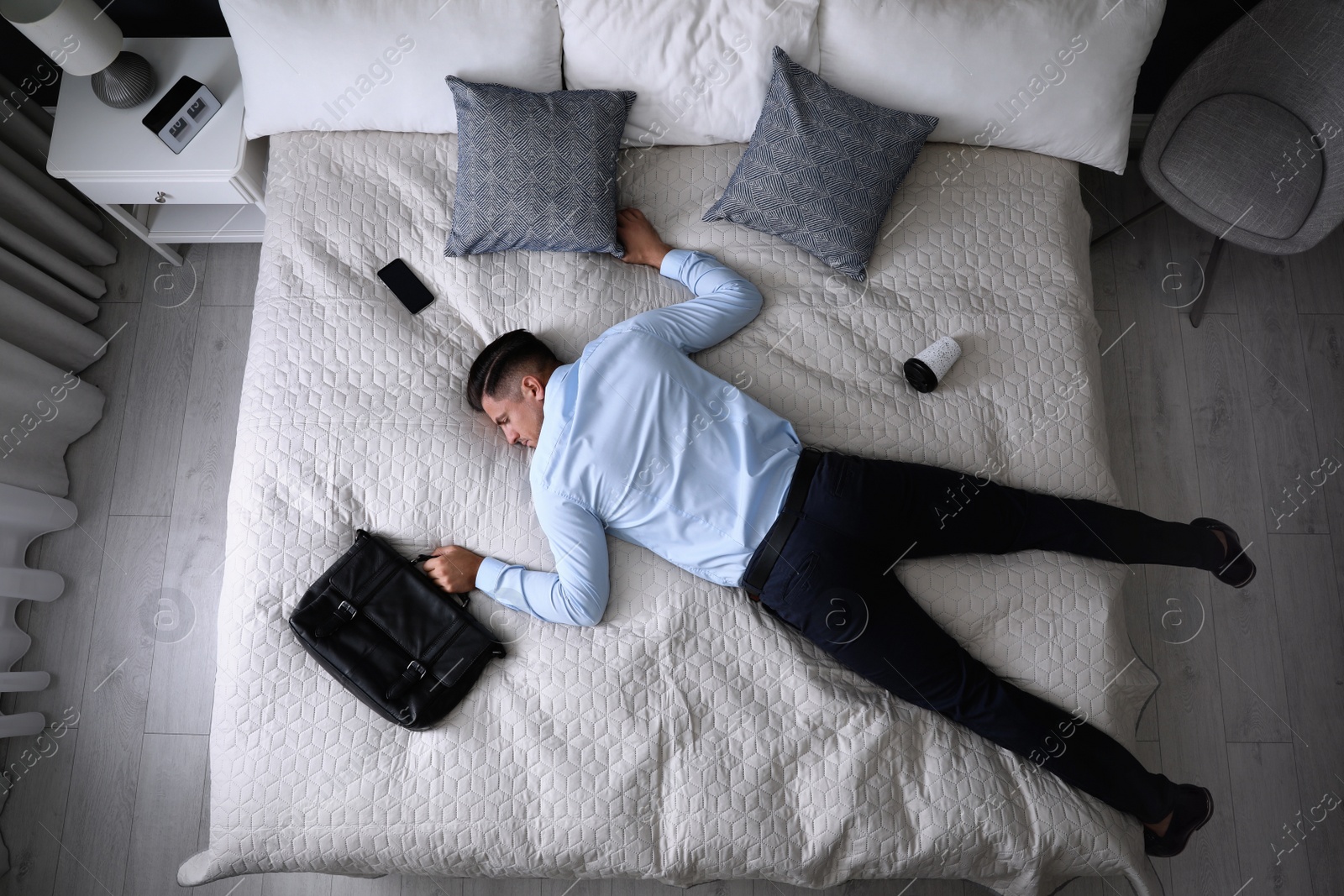 Photo of Exhausted businessman in office wear sleeping on bed at home after work, above view