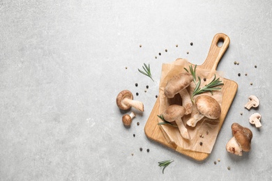 Photo of Flat lay composition with fresh wild mushrooms on light grey table, space for text