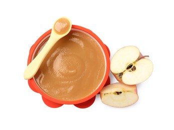 Photo of Tasty baby food in bowl, spoon and cut apple isolated on white, top view