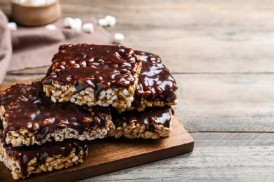 Photo of Delicious rice crispy treats on wooden table, closeup