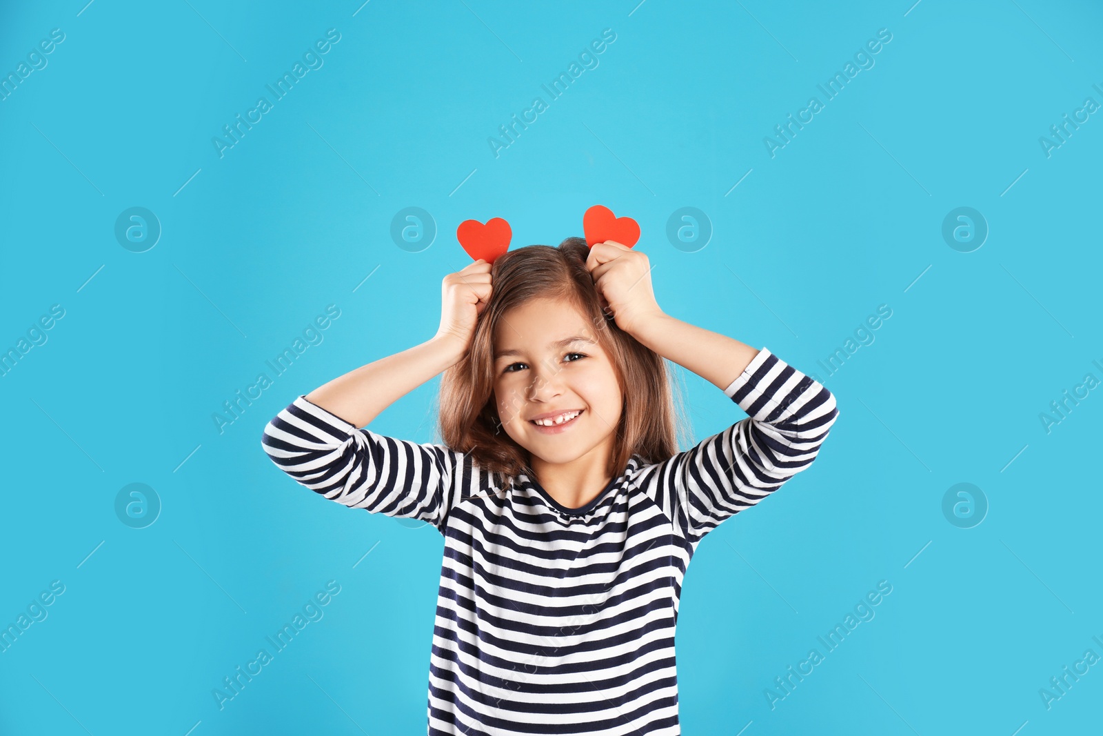 Photo of Portrait of girl with paper hearts on color background