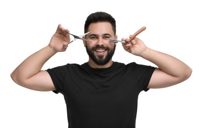 Handsome young man with mustache holding blade and scissors on white background