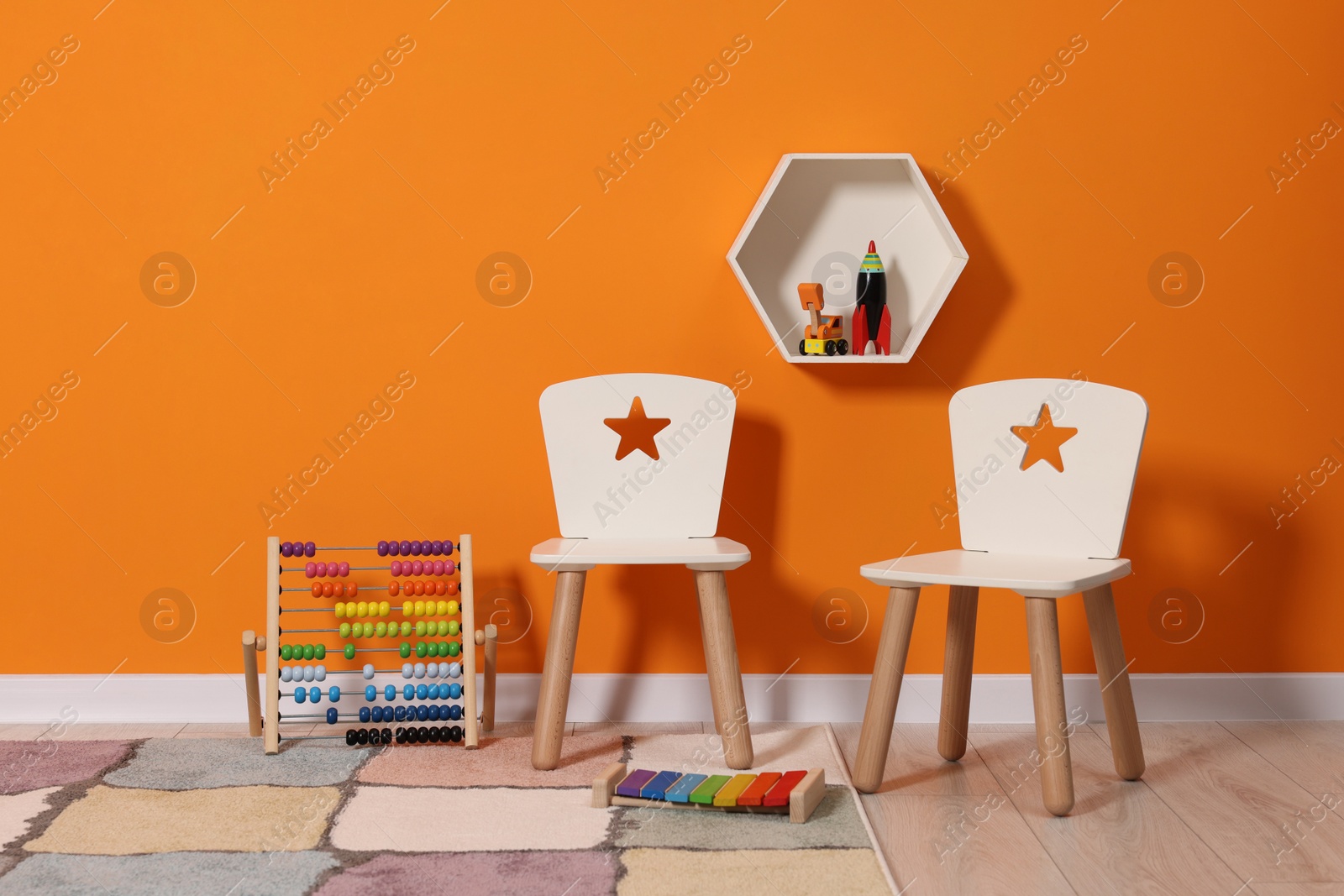 Photo of Beautiful children's room with bright orange wall and furniture. Interior design