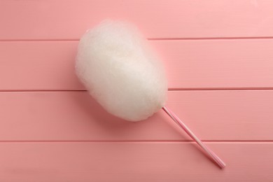 Photo of One sweet cotton candy on pink wooden table, top view