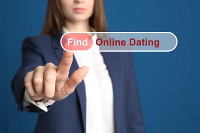 Woman pointing at search bar with request Online Dating on blue background, closeup
