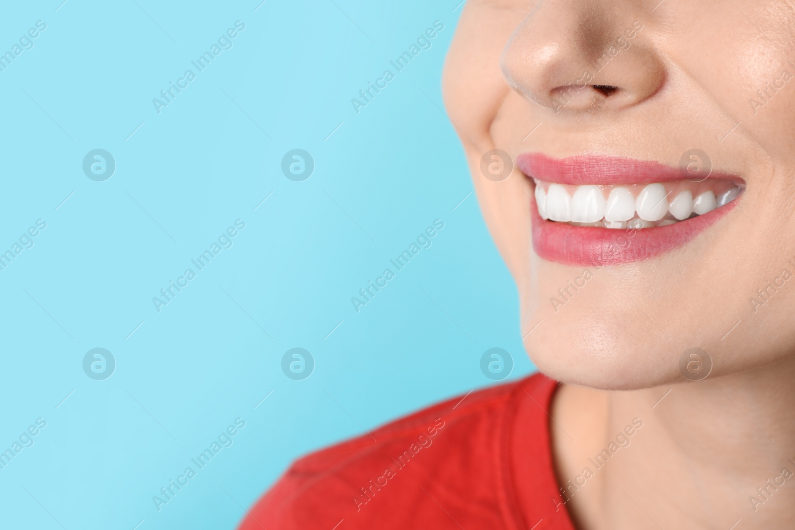 Photo of Smiling woman with perfect teeth on color background, closeup. Space for text