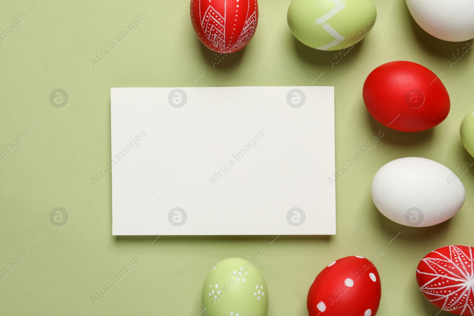 Photo of Flat lay composition of painted Easter eggs and card on color background, space for text