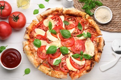 Photo of Delicious Caprese pizza on white wooden table, flat lay