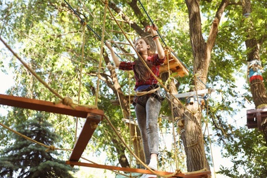 Teenage girl climbing in adventure park. Summer camp