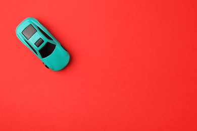 Photo of One light blue car on red background, top view. Space for text