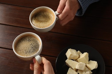 Photo of Women having coffee break at wooden table, above view