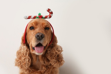 Photo of Adorable Cocker Spaniel dog in festive headband on white background, space for text