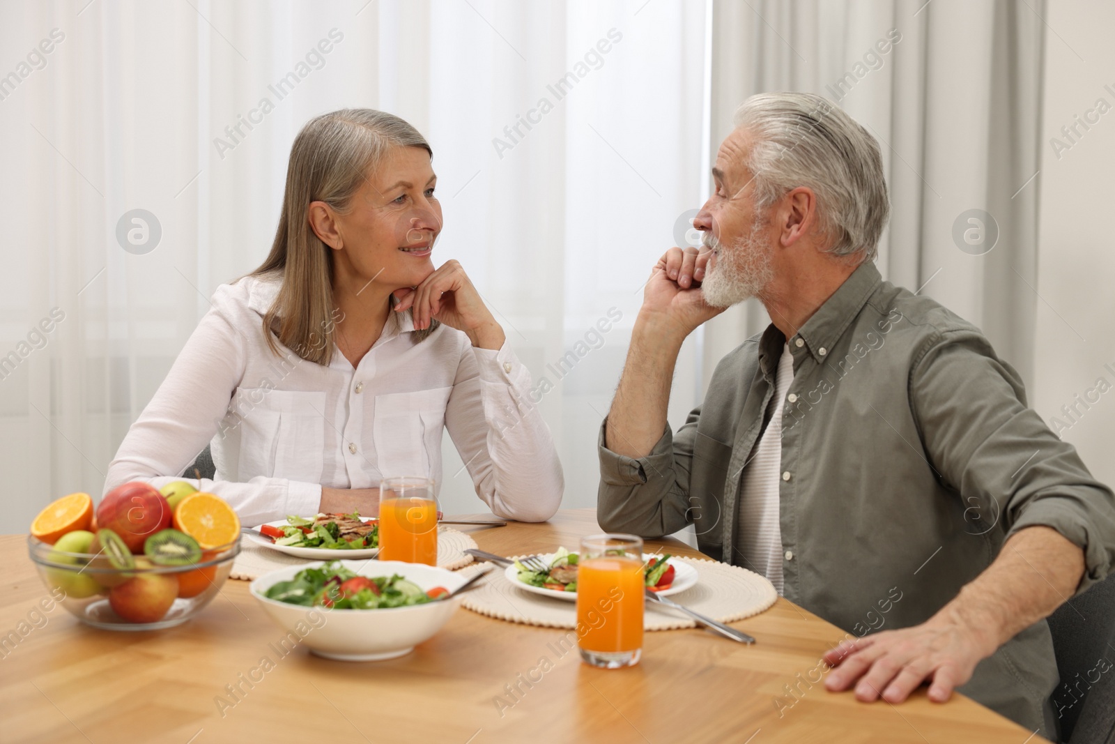 Photo of Happy senior couple having dinner at home