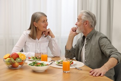 Happy senior couple having dinner at home