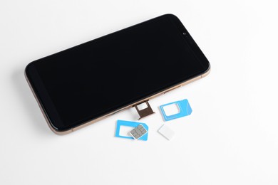 Photo of SIM cards and mobile phone on white table