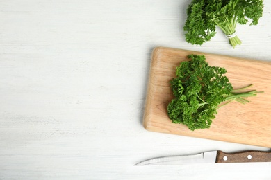 Photo of Flat lay composition with fresh green parsley on wooden table, space for text