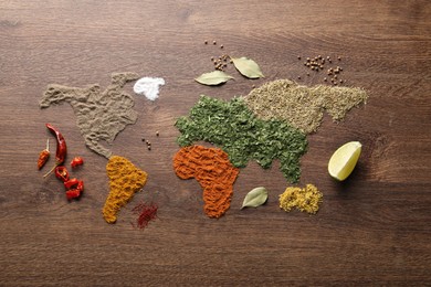 World map of different spices on wooden table, flat lay