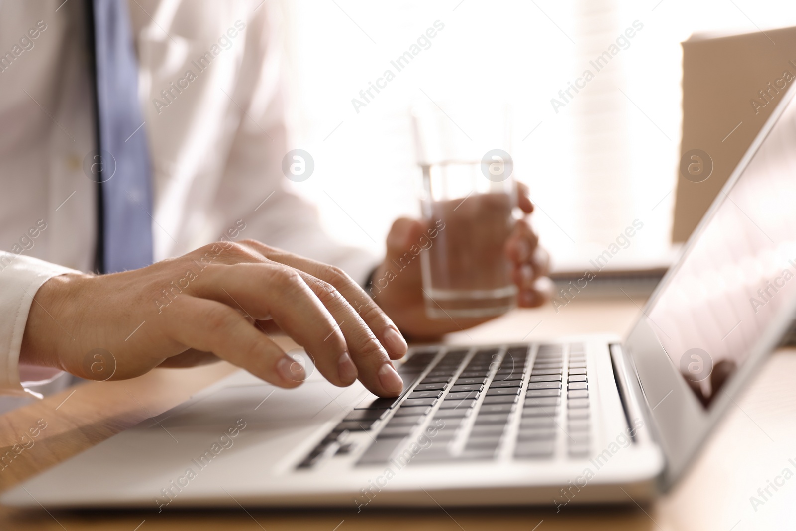 Photo of Man working with laptop in office, closeup of hand