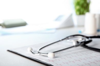 Stethoscope, cardiogram and forms on table, closeup. Cardiology service