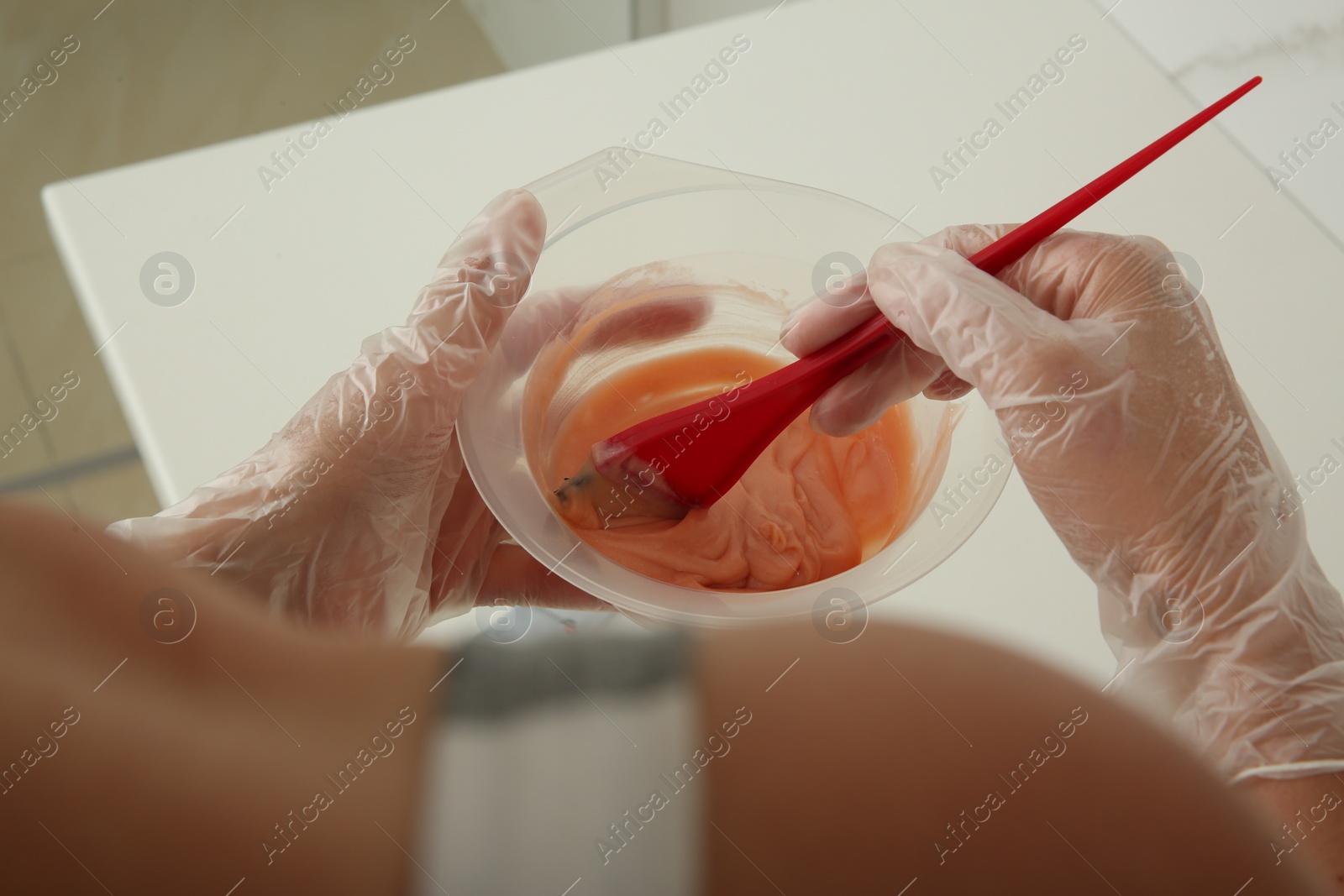 Photo of Woman preparing hair dye in bowl at home, closeup