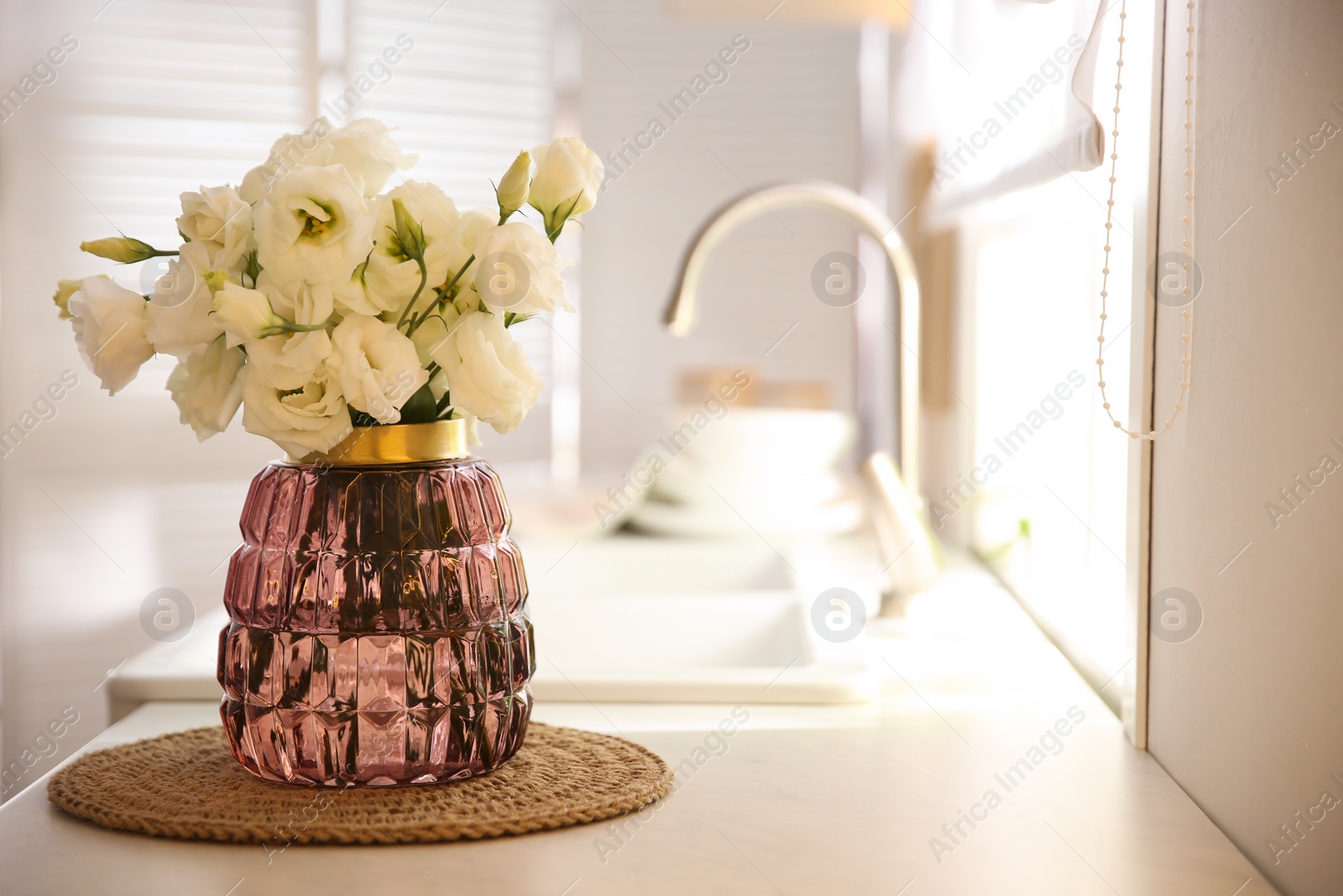 Photo of Bouquet of beautiful flowers on countertop in kitchen, space for text. Interior design