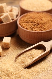 Photo of Different types of sugar on wooden table, closeup