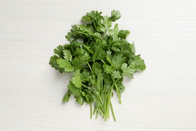 Photo of Bunch of fresh green cilantro on white wooden table, top view