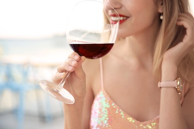 Photo of Young woman with glass of red wine outdoors