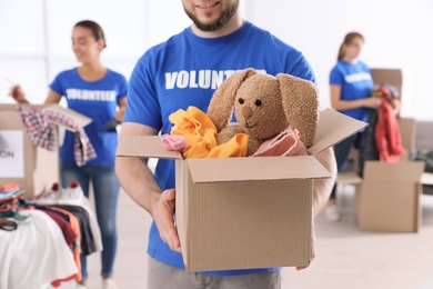 Male volunteer holding box with donations indoors