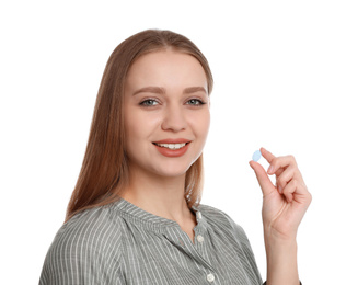 Young woman with vitamin pill on white background